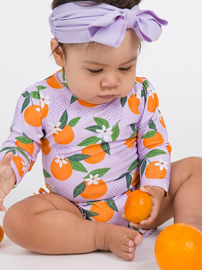 RuffleButts Baby Girls UPF 50+ Sun Protection Novelty Print Long Sleeve One Piece Rash Guard Swimsuit with Zipper