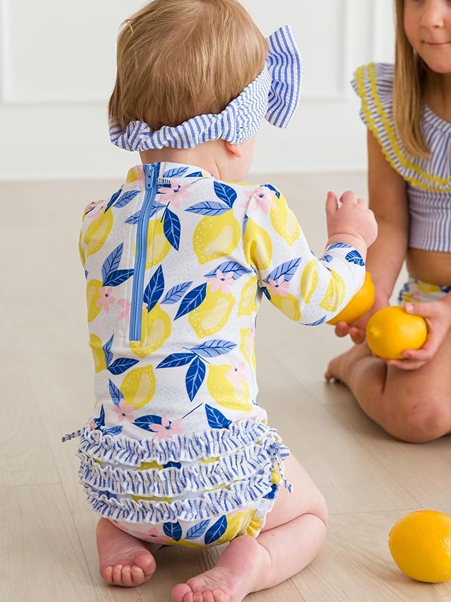 RuffleButts Baby Girls UPF 50+ Sun Protection Novelty Print Long Sleeve One Piece Rash Guard Swimsuit with Zipper